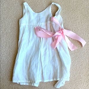 Little girls linen dress with pink bow closure.
